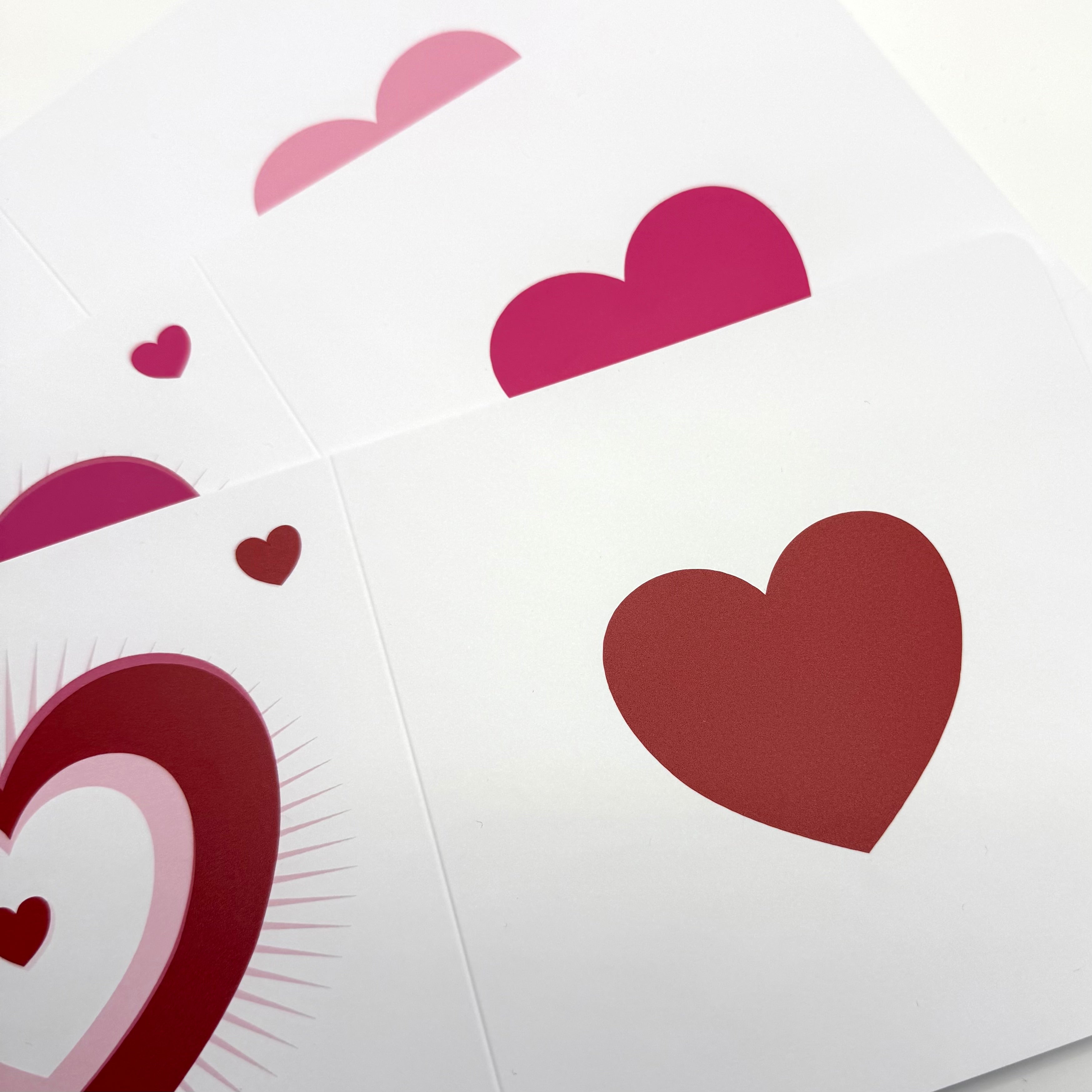 Handmade ceramic keepsake cards with red and pink heart designs on white backgrounds