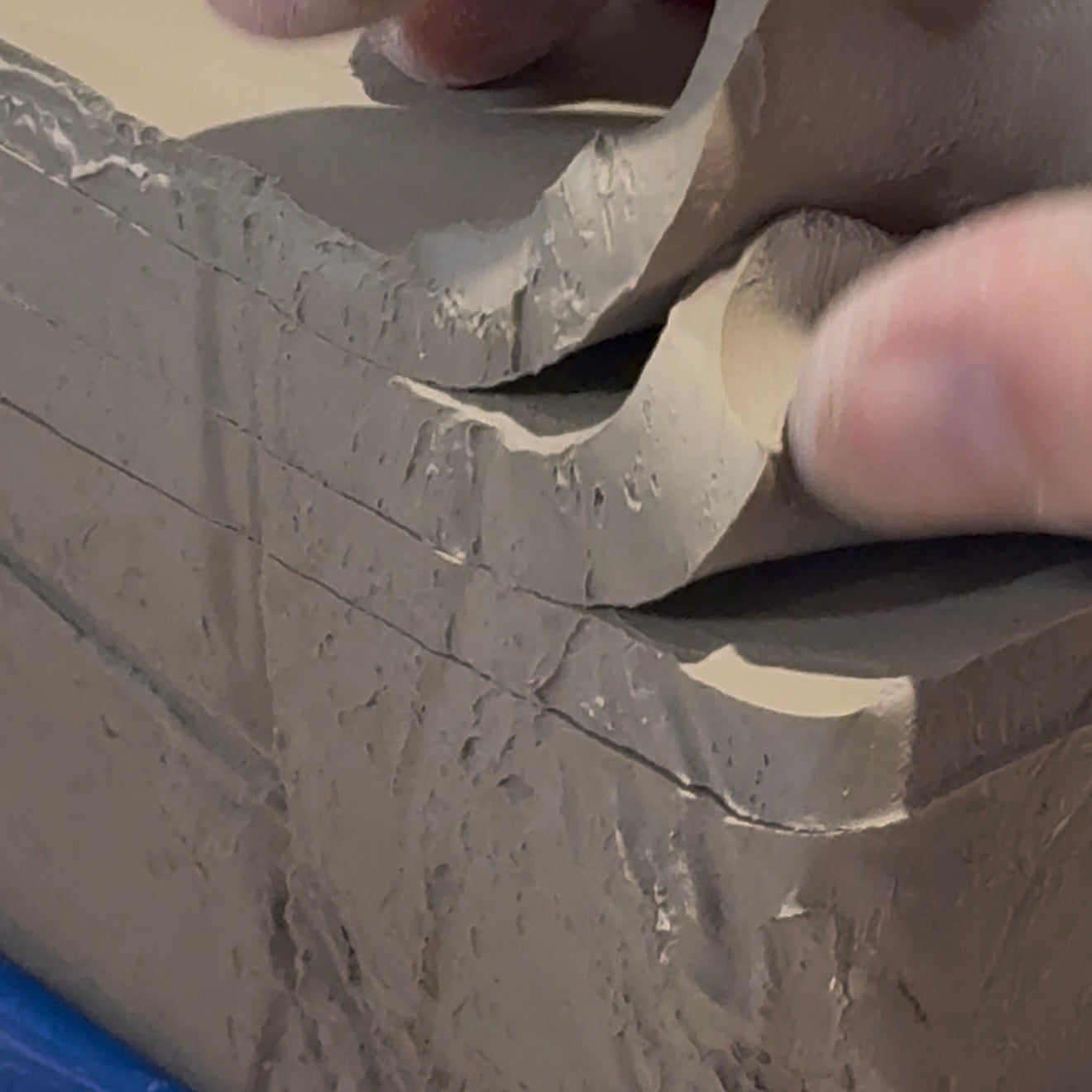Close-up of hands shaping stacked raw ceramic clay for handmade keepsake cards